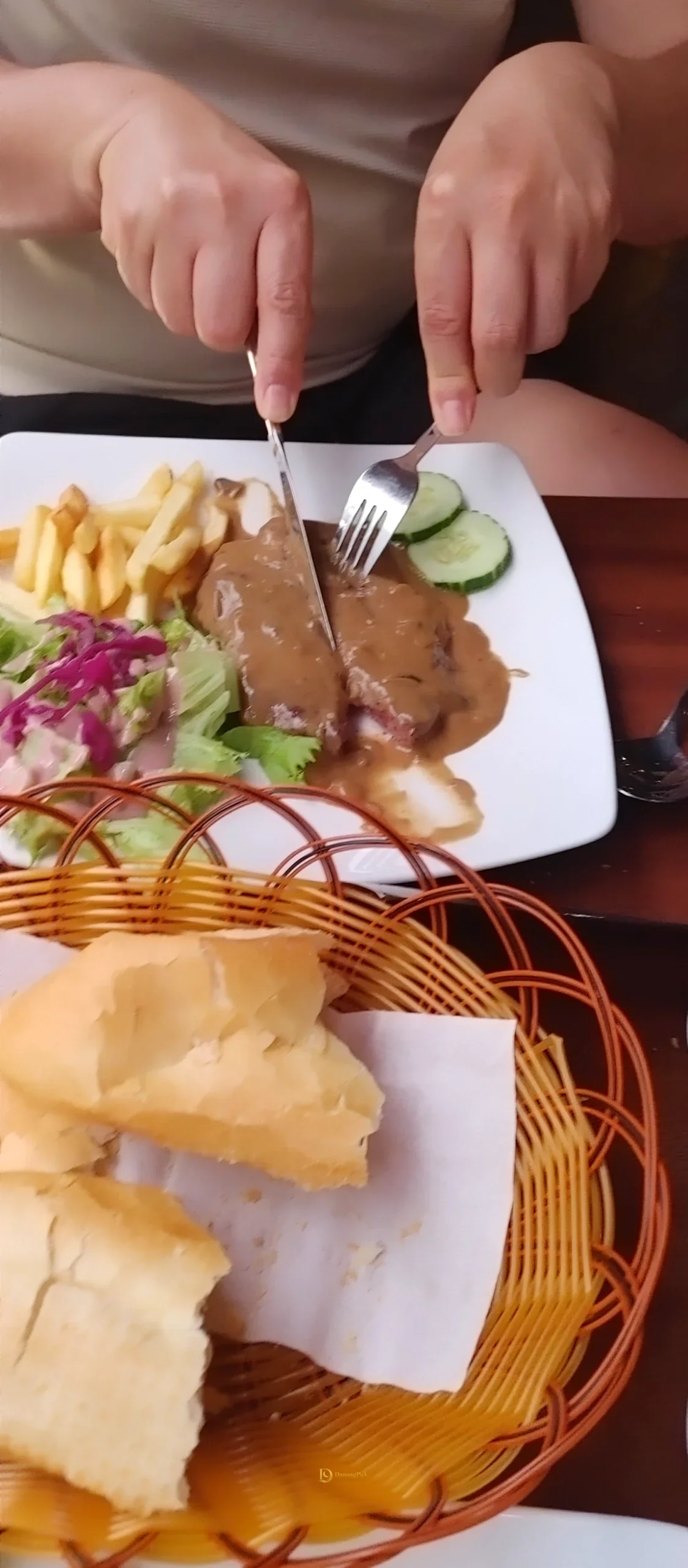 버섯 소스를 얹은 다낭 PapaSteak 스테이크를 썰고 있는 모습